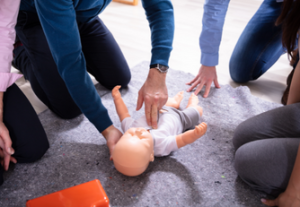 Student giving CPR to fake baby | American Heart Association Training